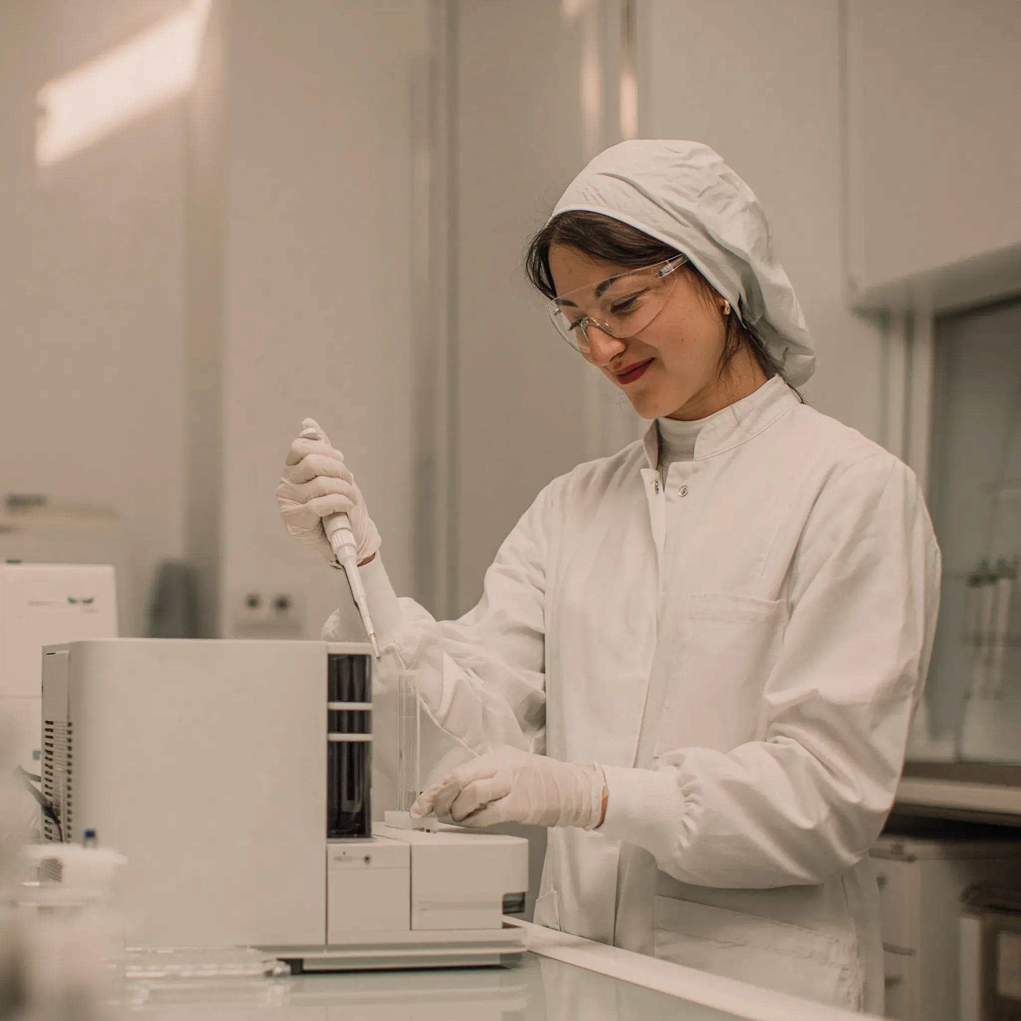 Lab technician in PPE working in a clean modern lab